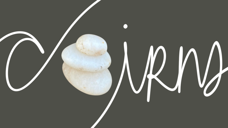 a mixed media word art composition that says "cairns" with three stacked pebbles to represent the letter A